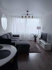 a living room with a couch and a tv at EVA apartment in Marijampolė