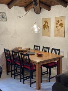 a dining room with a wooden table and chairs at Mansarda al Noce in Pellizzano +25 photos
