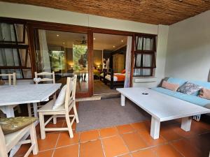 a living room with a table and a couch at MALI Boutique Lodge & Tube 'n Axe Budget Accommodation in Stormsrivier