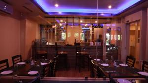 a dining room with tables and chairs and a bar at Komal Hotel in Lālbhitti