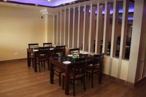 a dining room with wooden tables and chairs at Komal Hotel in Lālbhitti +12 photos