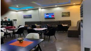 a restaurant with tables and chairs and a couch at Bromford Hotel Owerri in Owerri