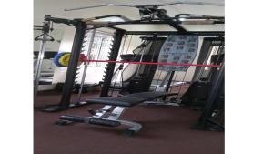 a gym with a bench and a barbell at Bromford Hotel Owerri in Owerri