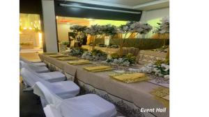 a row of tables with white chairs and flowers at Bromford Hotel Owerri in Owerri