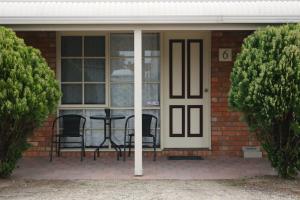 a front door of a house with a table and chairs at Kerang Motel in Kerang