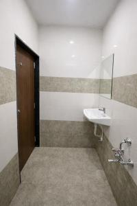 a bathroom with a sink and a mirror at StayGuru Hari Om Residency in Bhuj