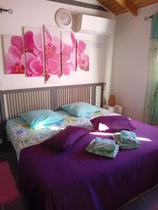 a bedroom with a purple bed with towels on it at Gîte Anolis in Saint-François