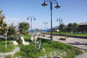 a park with benches and street lights and the ocean at Thalassa Studios in Faliraki