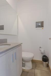 a white bathroom with a toilet and a sink at Luxury Studio El Poblado Pool Rooftop 4th Floor in Medellín +11 photos