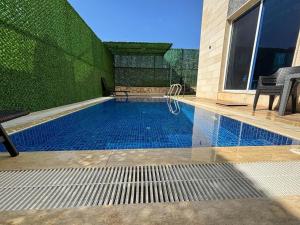 ein kleines Schwimmbecken mit einer begrünten Wand in der Unterkunft Angela chalet in Kfar Roummâne