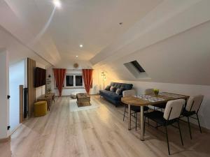 a living room with a table and a couch at Appartement douillet in Haspres +9 photos