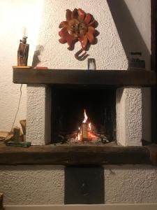 a fireplace with a flower on top of it at Mansarda al Noce in Pellizzano