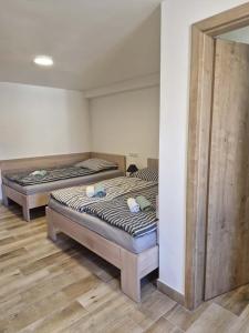 two twin beds in a room with wooden floors at Sklípek u Štýblů in Velké Němčice