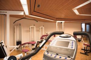 a gym with rows of exercise equipment and a treadmill at Hotel Landgut Burg in Weinstadt