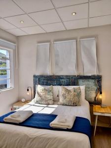 a bedroom with a large bed with two pillows at The Tipsy Expat - Paarl - Self Catering Apartment in Paarl