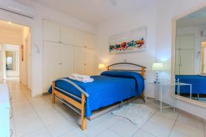 a bedroom with a blue bed and a mirror at Resitour - Tala Hills in Tala