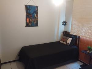 a bedroom with a black bed and a picture on the wall at UniversiFlat in Ponta Grossa +38 photos