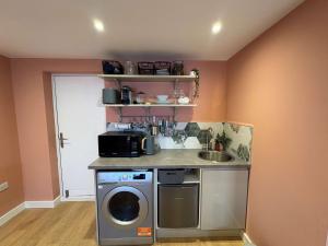 a kitchen with a washing machine and a sink at Studio Flat in Seymour Road in Bristol