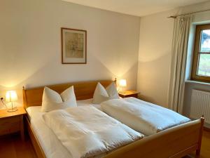 a bedroom with a bed with white sheets and pillows at Ferienwohnung Alpenrose Sommer-Hörnerbahnen kostenlos in Obermaiselstein