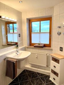 a bathroom with a sink and a mirror at Ferienwohnung Alpenrose Sommer-Hörnerbahnen kostenlos in Obermaiselstein