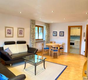 a living room with a couch and a table at Ferienwohnung Alpenrose Sommer-Hörnerbahnen kostenlos in Obermaiselstein