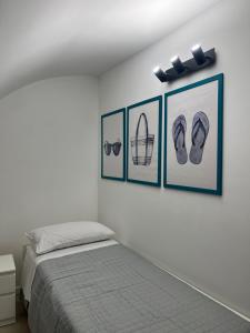 a bedroom with three pictures of shoes and a bed at Siculía in Noto