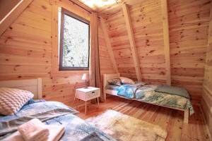 a bedroom with two beds in a log cabin at Green Hideaway SPA in Žabljak