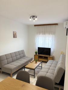 a living room with two couches and a flat screen tv at Kozy Apartments in Međugorje