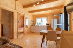 a kitchen and dining room with a table and chairs at Proxial - domki letniskowe in Międzywodzie