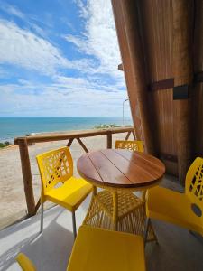 a table and chairs on a balcony with the beach at Cabana Redonda Beach in Icapuí