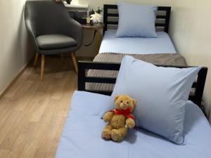 Ein Teddybär sitzt auf einem Bett in einem Zimmer in der Unterkunft Kust Hostel in Kiew