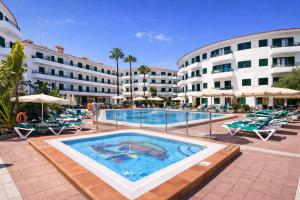 a swimming pool in a resort with chairs and buildings at Las Faluas by Youroom in Playa del Ingles