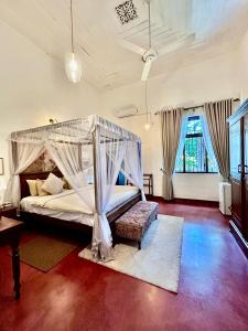 a bedroom with a bed with a canopy at Colonial Boutique Villa Kandy in Kandy +57 photos