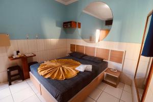 a bedroom with a bed with a round mirror at Hotel Bellamy in São Paulo