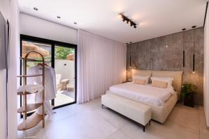 a bedroom with a white bed and a balcony at אחוזת דוד - וילה יוקרתית עם בריכה פרטית מחוממת ומקורה in Hatzor haglilit