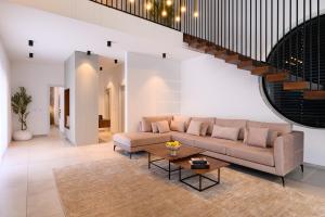 a living room with a couch and a table at אחוזת דוד - וילה יוקרתית עם בריכה פרטית מחוממת ומקורה in Hatzor haglilit +16 photos