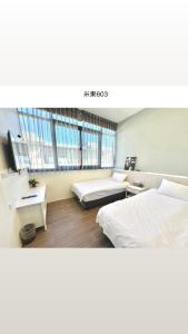a large room with two beds and a tv at Migo Homestay in Yilan City