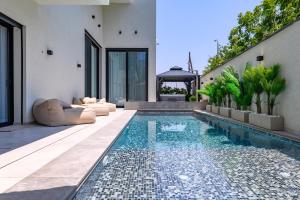a swimming pool in the backyard of a house at אחוזת דוד - וילה יוקרתית עם בריכה פרטית מחוממת ומקורה in Hatzor haglilit