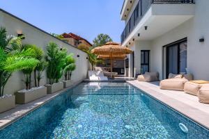an outdoor swimming pool with a villa at אחוזת דוד - וילה יוקרתית עם בריכה פרטית מחוממת ומקורה in Hatzor haglilit