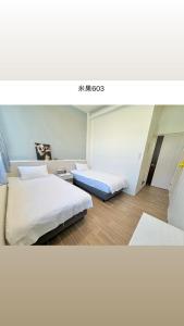 a room with two beds in a room at Migo Homestay in Yilan City