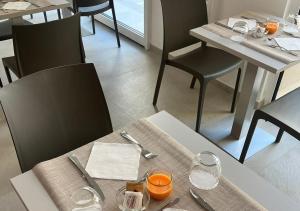 a dining room with a table and chairs with glasses at Boutique Hotel Magenta in Magenta +20 photos