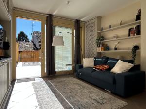 a living room with a blue couch and a large window at Blue Roof in Fidenza