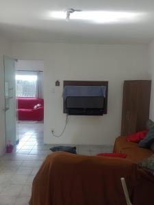 a room with two beds and a tv on the wall at Casa Wense - prox a praia in Ilhéus