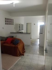 a white room with a bed and a kitchen at Casa Wense - prox a praia in Ilhéus