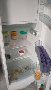 an open refrigerator filled with food and other items at Casa Wense - prox a praia in Ilhéus