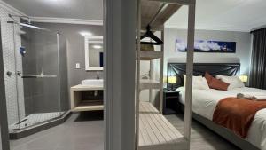 a bedroom with a bed and a bathroom with a shower at Ngandu at Sea in Meersig