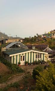 a white building with a green roof on a hill at Blackpool Farm House in Nuwara Eliya +15 photos