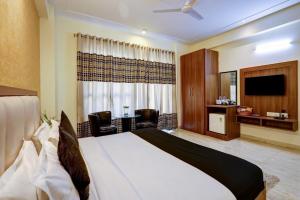 a hotel room with a bed and a television at Hotel The Luxe 18 - Golf Course Road in Gurgaon