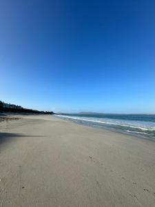 an empty beach with the ocean in the background at White Wicker House in Langebaan