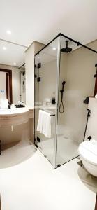 a bathroom with a glass shower and a toilet at Jayden Hotel in Medina +30 photos